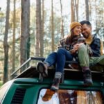 cheerful-couple-relaxing-on-a-rooftop-of-their-travel-van-in-nature-.jpg